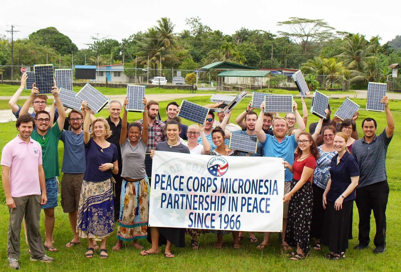 Peace Corps participants hold solar panels outdoors, highlighting global service in ASU's Peace Corps Prep certificate.