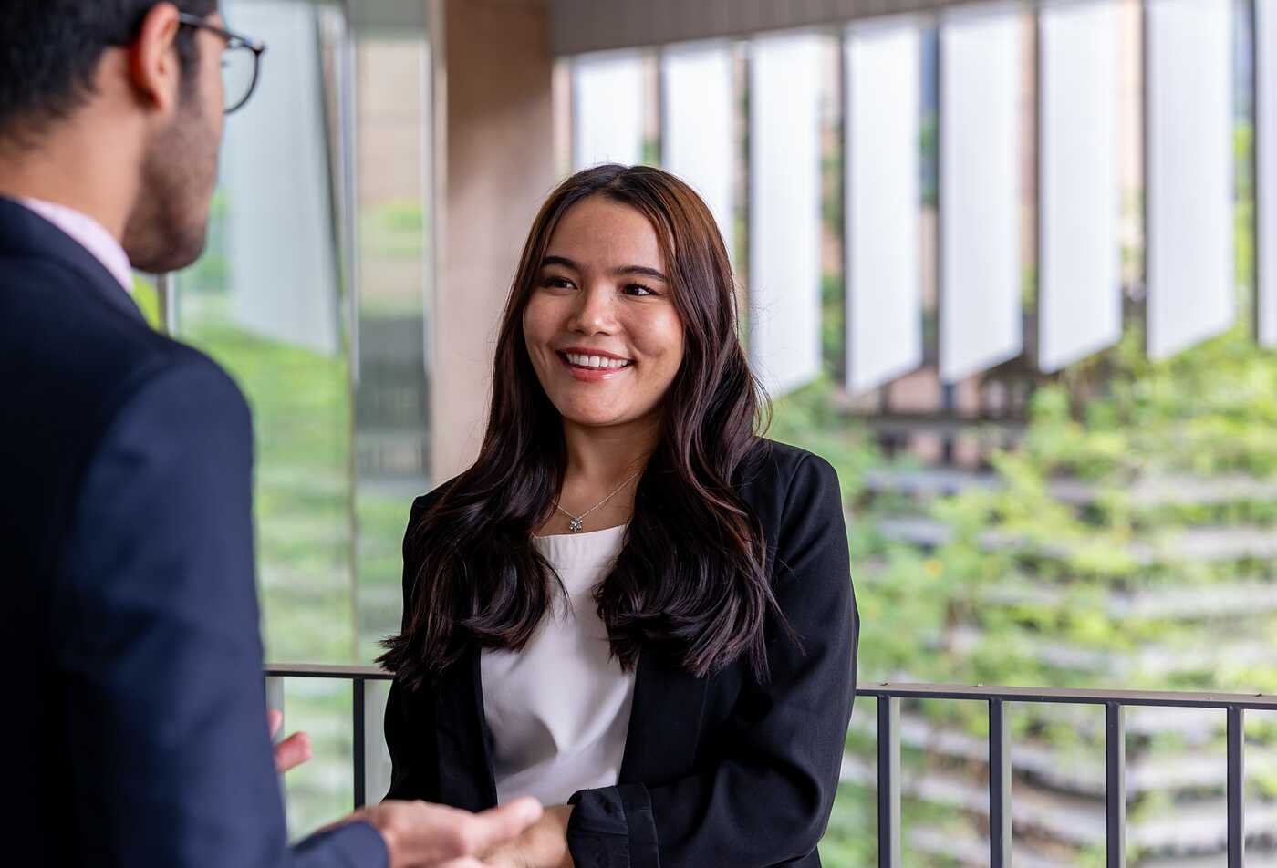 Two professionals discuss ideas in a workplace, reflecting career development in ASU's Professional Studies, AA program.