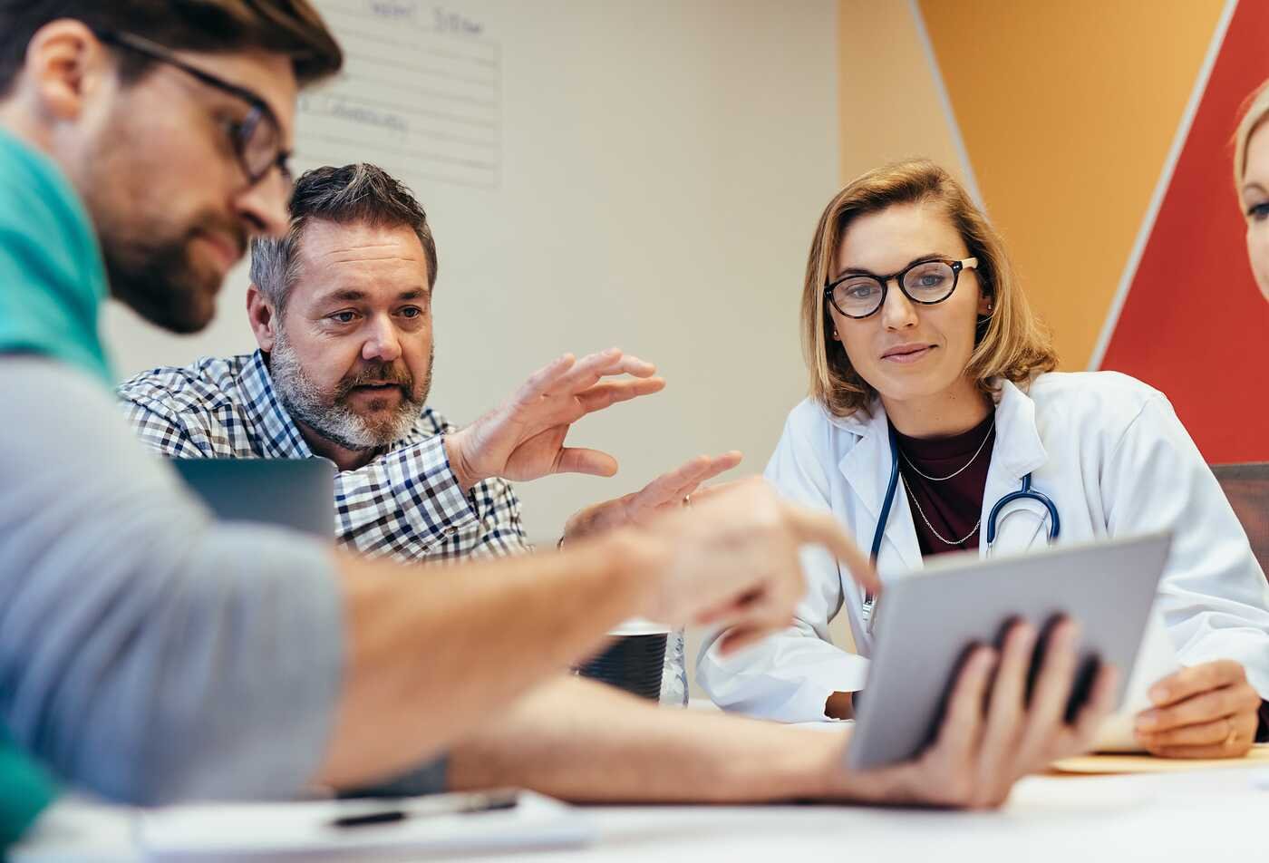 Medical professionals review a tablet, connecting health and communication in ASU's Technical Communication (Medical and Health), BS program.