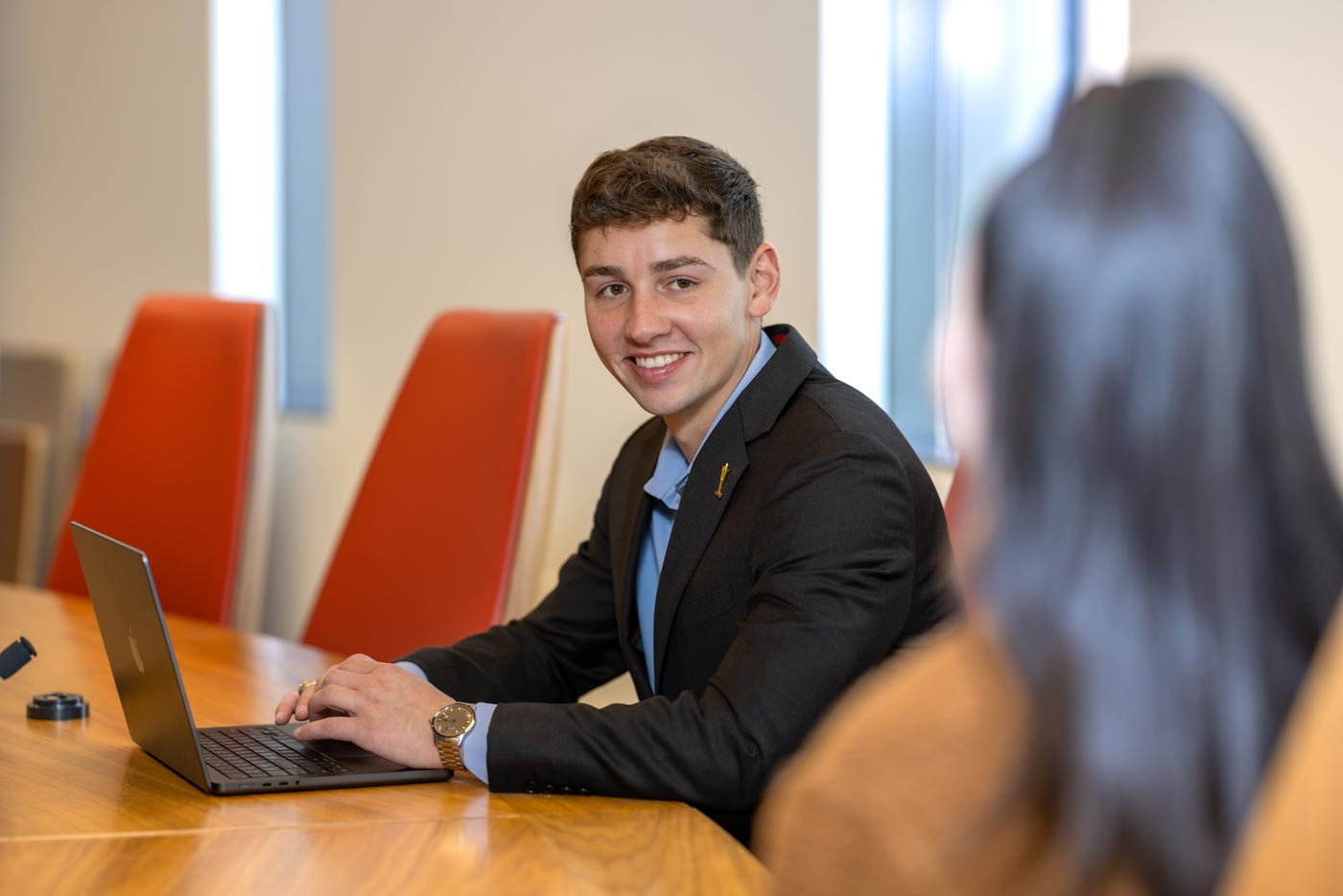 Two students engage in a discussion at a conference table, embodying collaborative learning in ASU's Sports Law and Business degree.