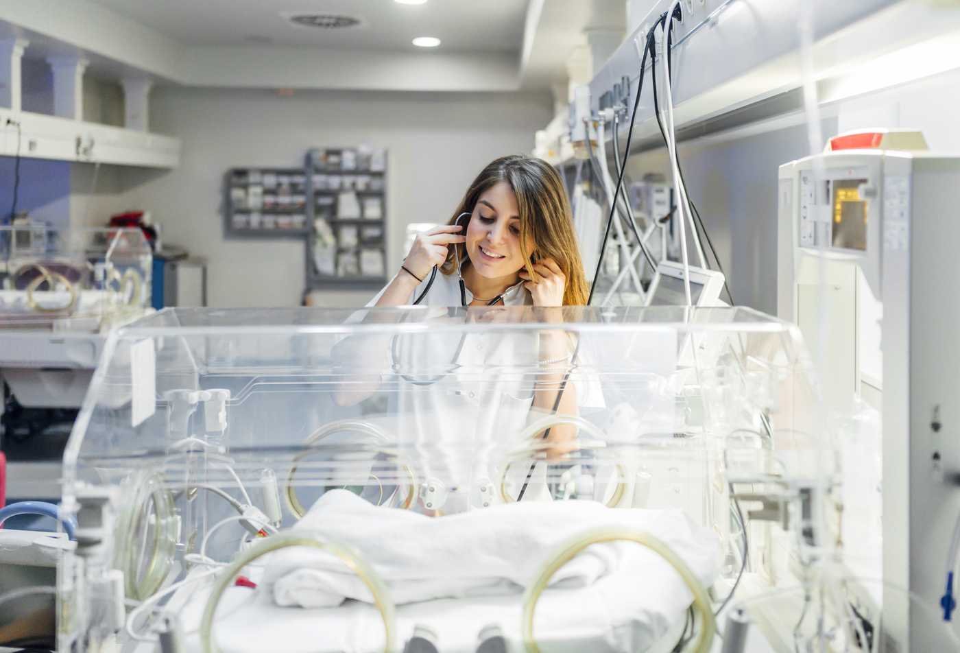 A DNP student assesses a newborn in a neonatal intensive care unit, reflecting the field explored in the Advanced Nursing Practice (Acute Care Pediatric Nurse Practitioner), DNP.