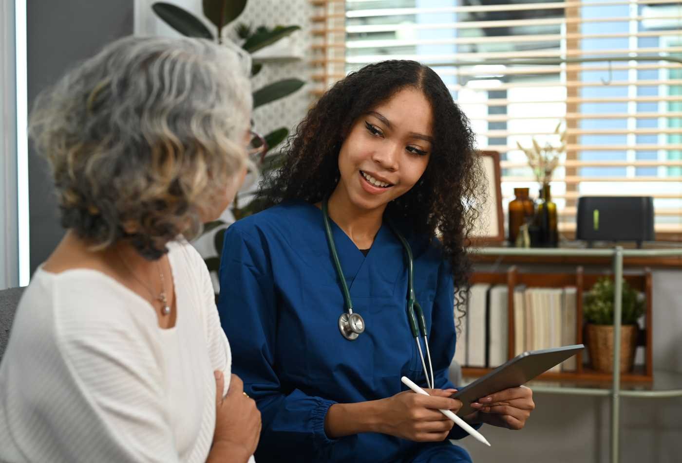 A DNP student discusses care with an older adult patient during a primary care visit, reflecting the field explored in the Advanced Nursing Practice (Adult-Gerontology Nurse Practitioner), DNP.