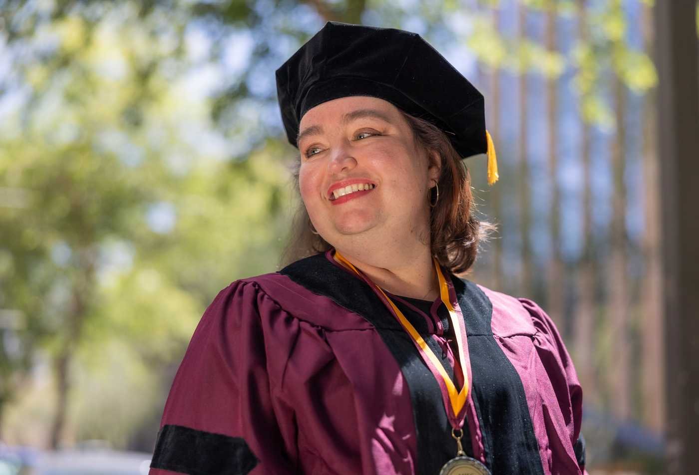 A DNP graduate in regalia celebrates completion of an advanced nursing education program.