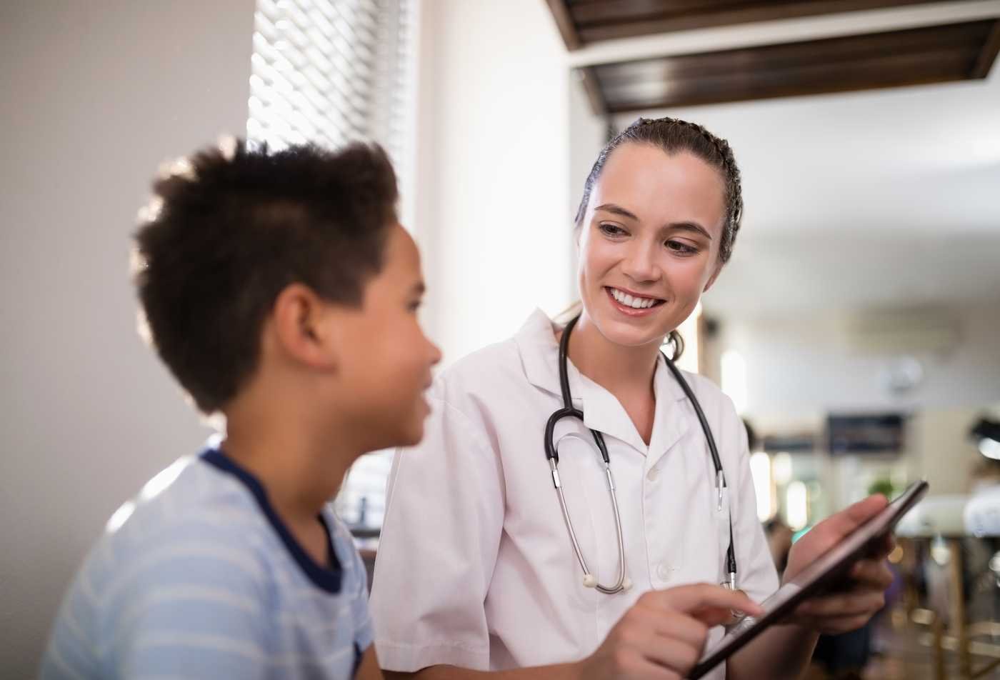 A student discusses care with a pediatric patient during a primary care visit, reflecting the field explored in the Family Nurse Practitioner (Graduate Certificate).