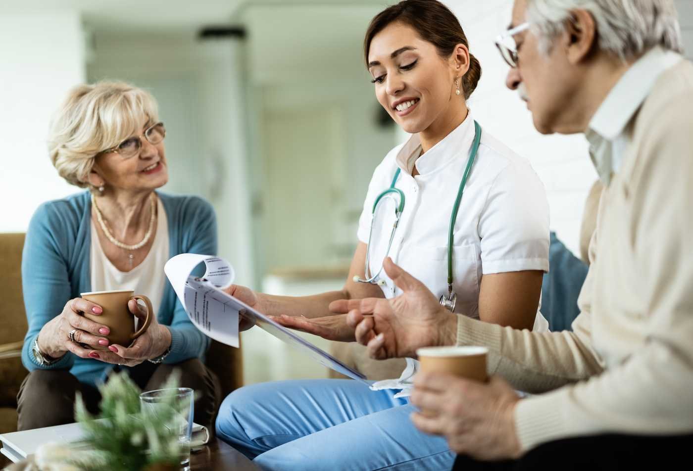 A health care coordinator reviews information with  patients during a planning discussion, represeting the field explored in the minor in Health Care Coordination.
