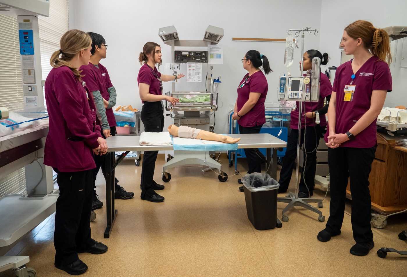 Students participate in a clinical simulation lab while learning patient care techniques, showcasing hands-on learning in the BSN in Nursing.