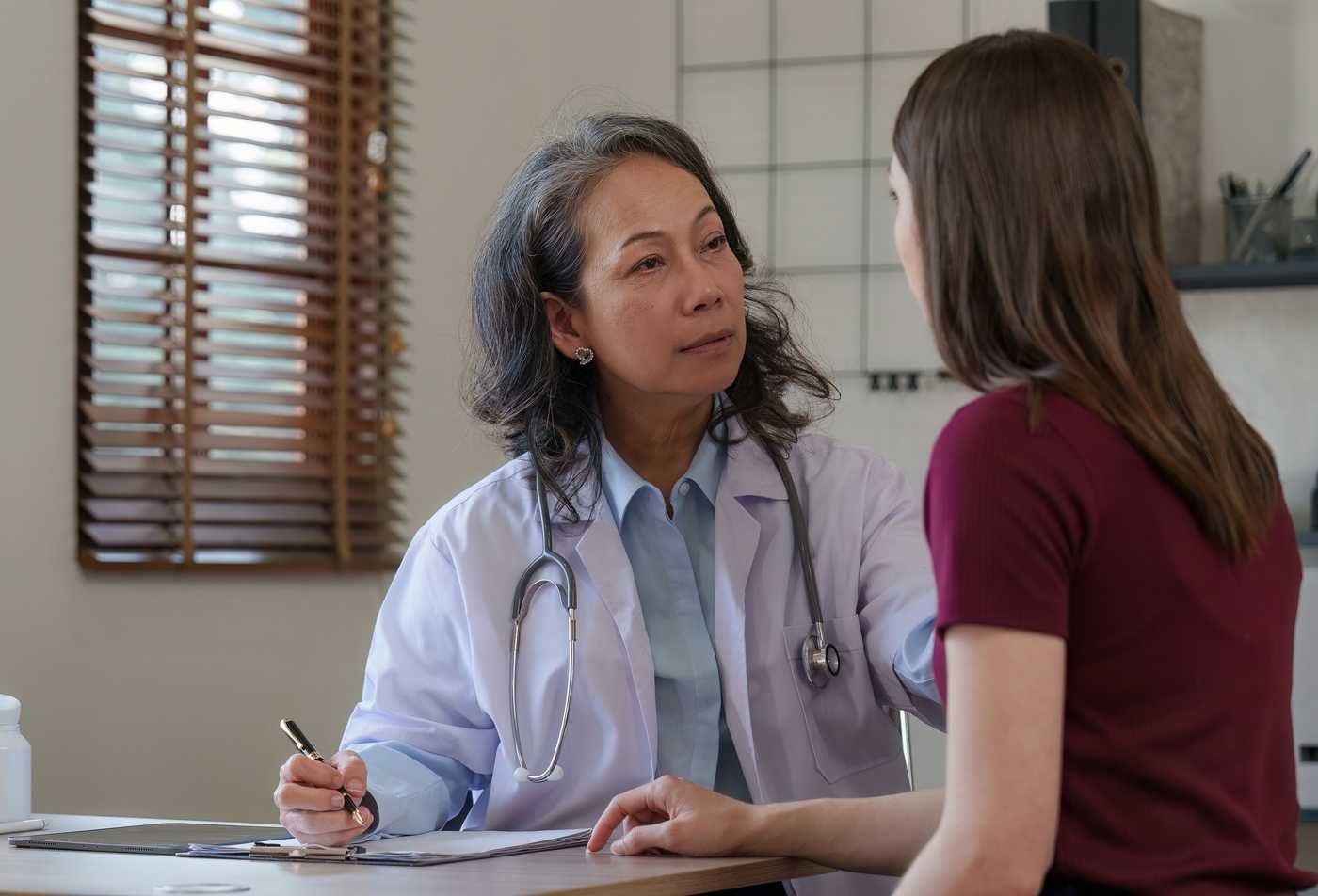 Two doctors engage in discussion, representing the expertise gained in the Women's Health Nurse Practitioner (Graduate Certificate).