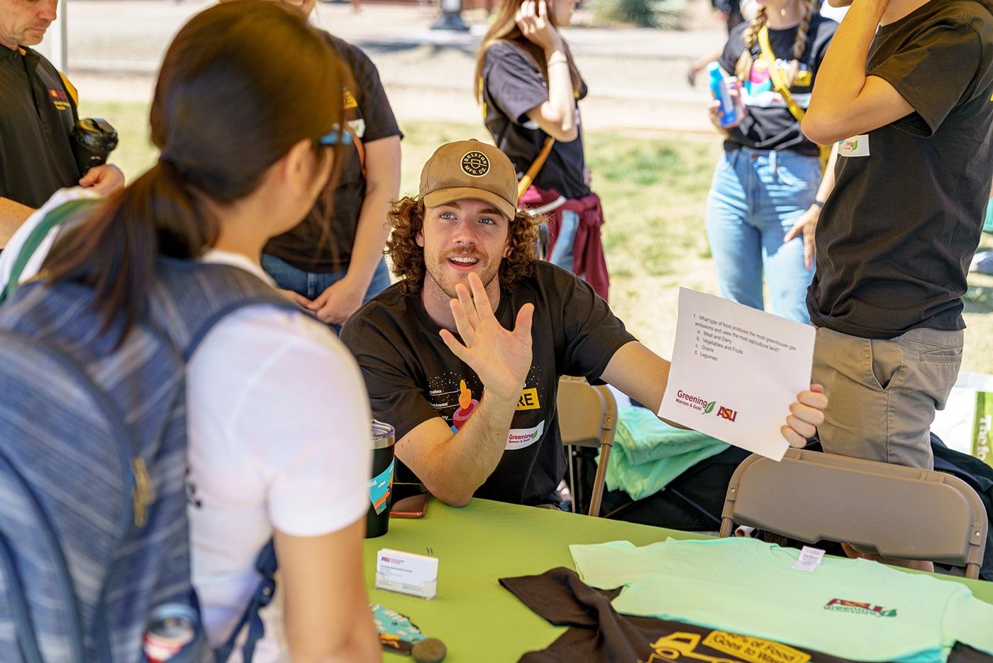 Greening ASU representatives connect with students at an outdoor event, showing the skills honed in the Special Events Management certificate.