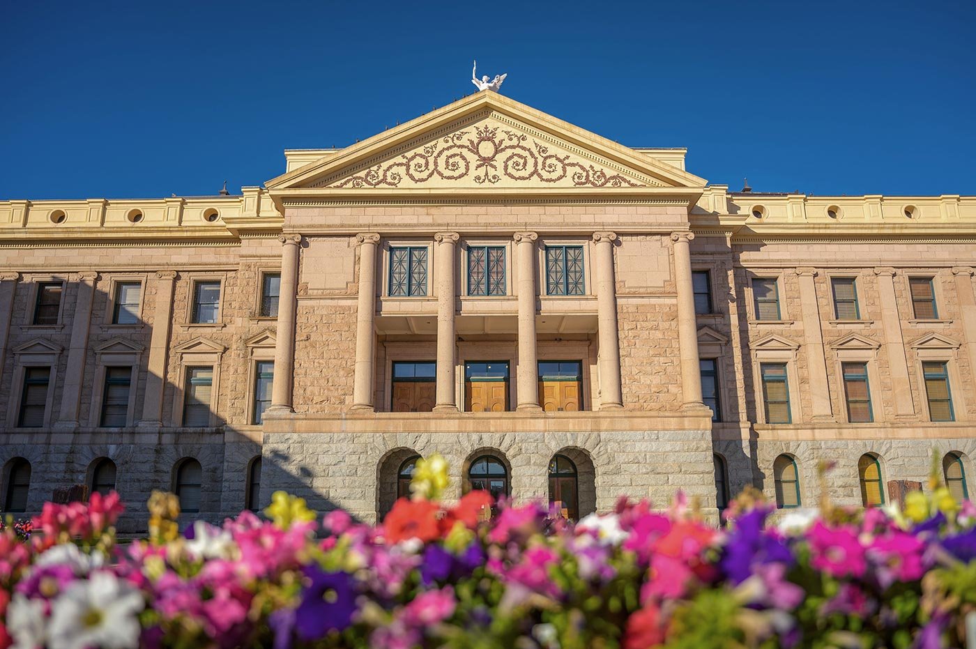 A government building rises behind colorful flowers, reflecting the policy engagement central to ASU's Community Advocacy and Social Policy degree.