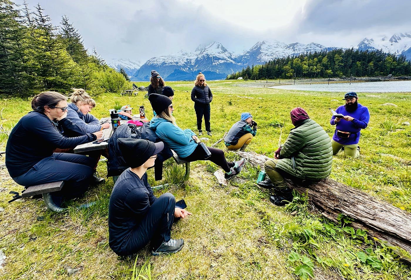 Students take notes and talk together outdoors, mirroring the hands-on inquiry central to ASU's Community Resources and Development PhD.