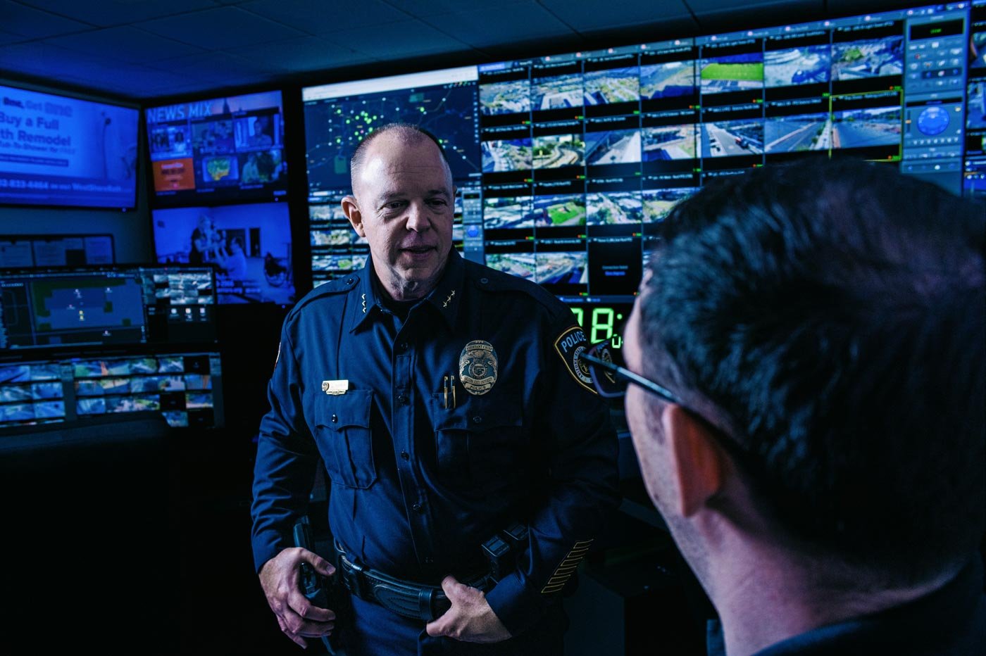Police officers discuss operations in a technology-rich control room, illustrating real-world applications in ASU’s Crime Analysis program.