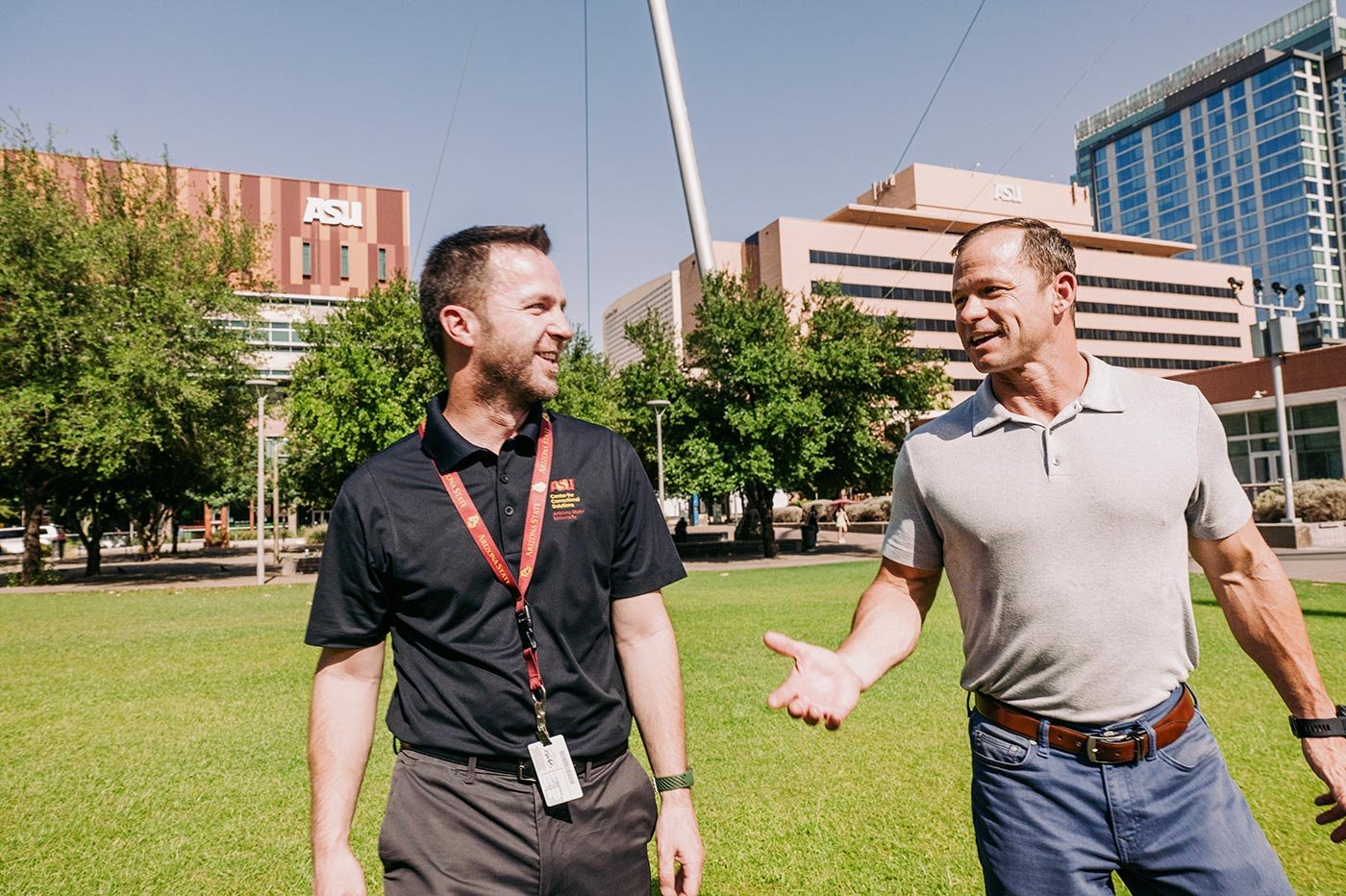 Students engage in a conversation on a green campus lawn, symbolizing collaboration and networking in ASU’s MA in Criminal Justice program.