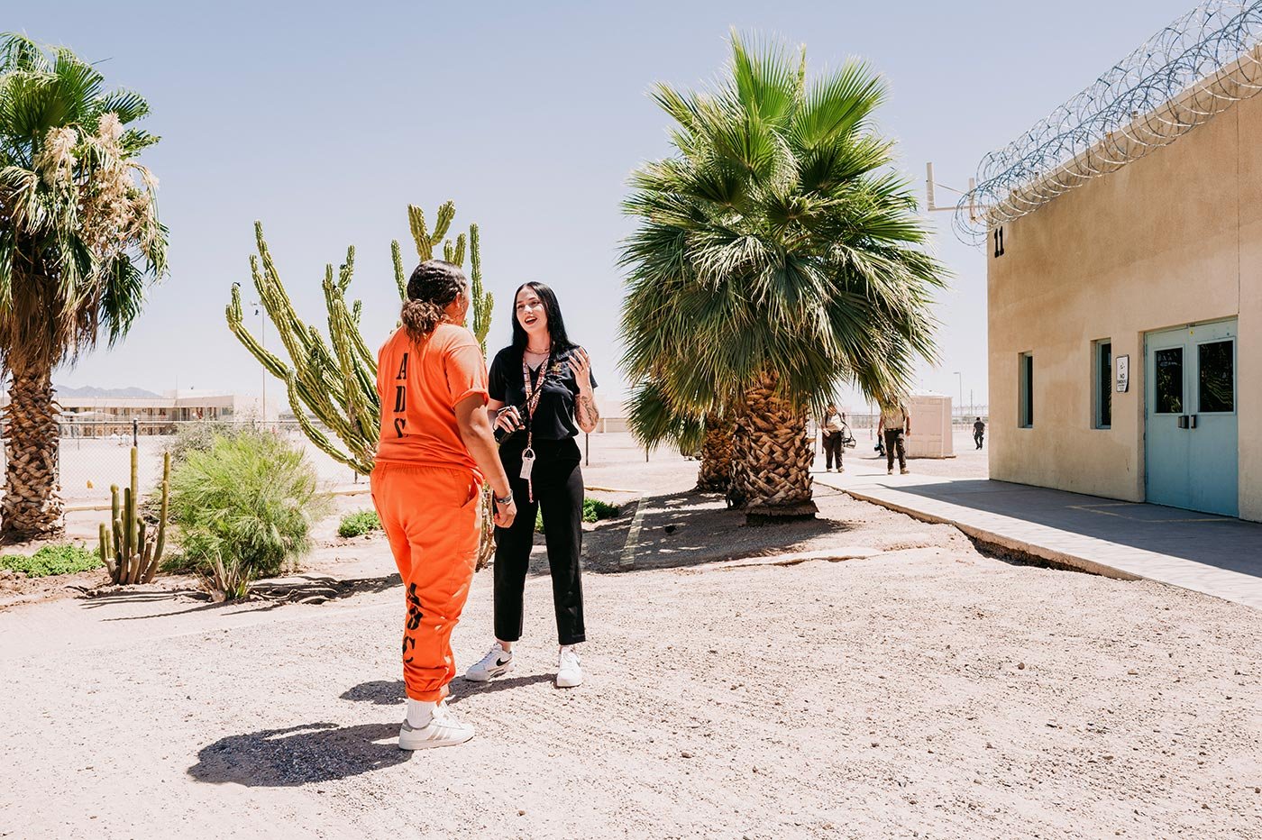 An ASU student talks with a woman in an orange jumpsuit at a correctional facility, illustrating hands-on learning in Correctional Studies.