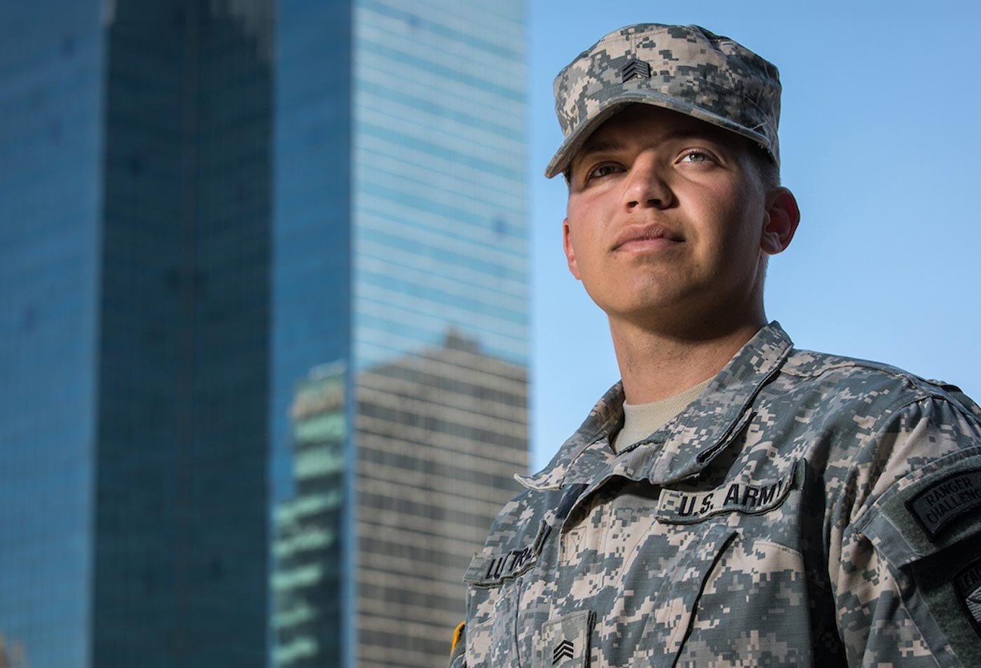 A student in military uniform stands before a modern building, reflecting the dedication central to ASU's Emergency Management Essentials program.
