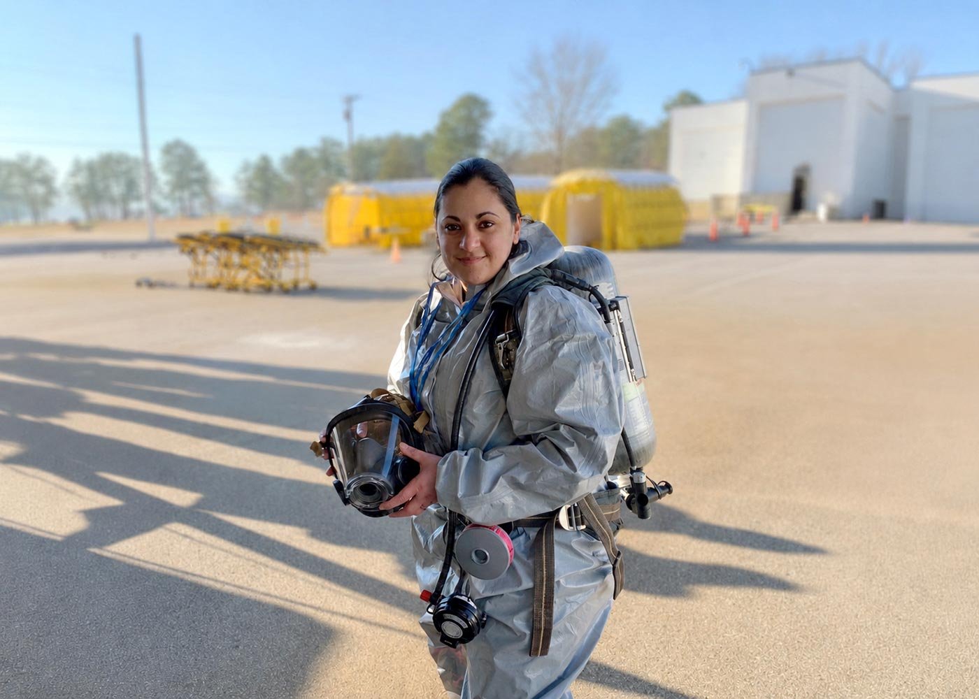A student in protective gear holds a respirator during training, reflecting real-world scenarios in ASU's Emergency Management degree.