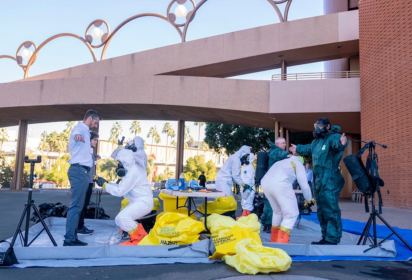 Responders in protective suits practice emergency techniques outdoors, reflecting the hands-on training in ASU's Emergency Management degree.