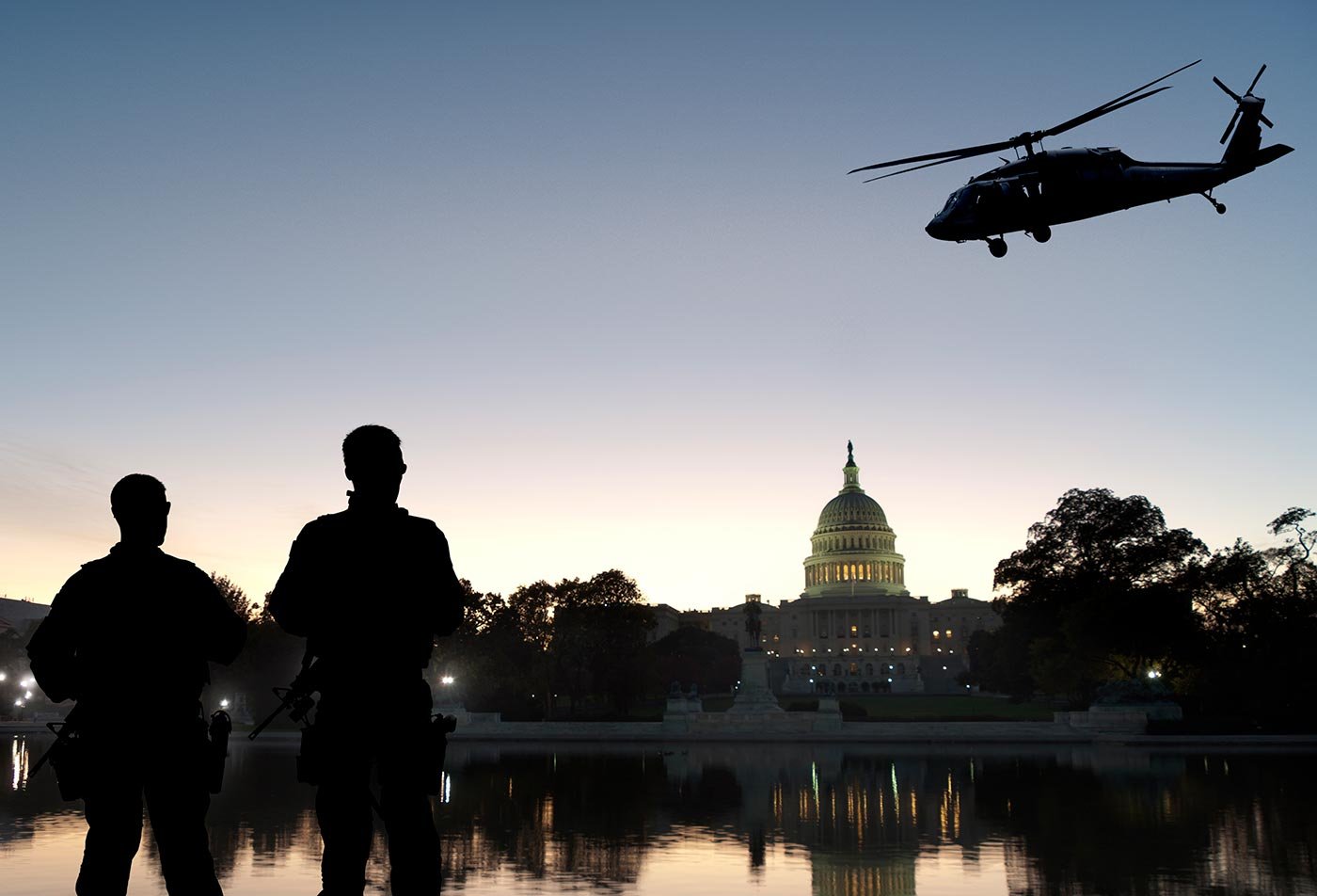 Two soldiers watch a helicopter circle the U.S. Capitol beside a reflecting pool, capturing the scope of ASU's Homeland Security certificate.