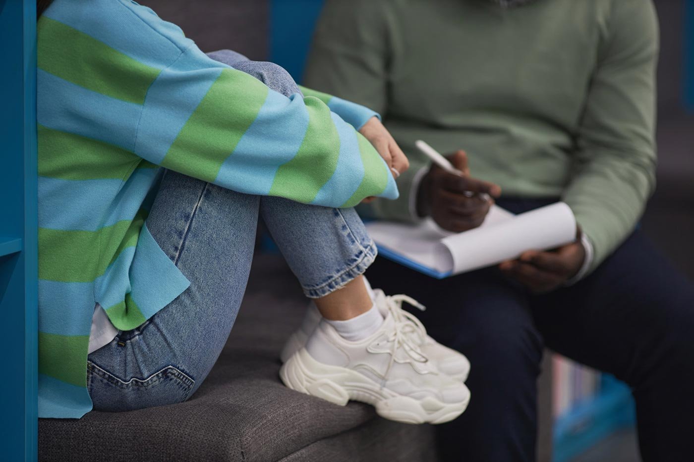 A student takes notes while talking with someone at a juvenile detention center, reflecting the practical training in ASU's Juvenile Justice program.