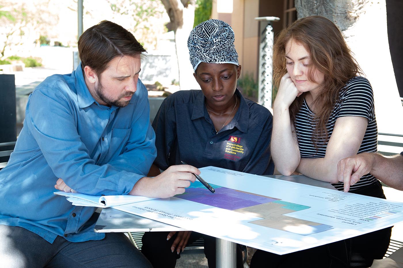 Students study a map together outdoors, reflecting the hands-on learning within ASU's Nonprofit Administration concentration.