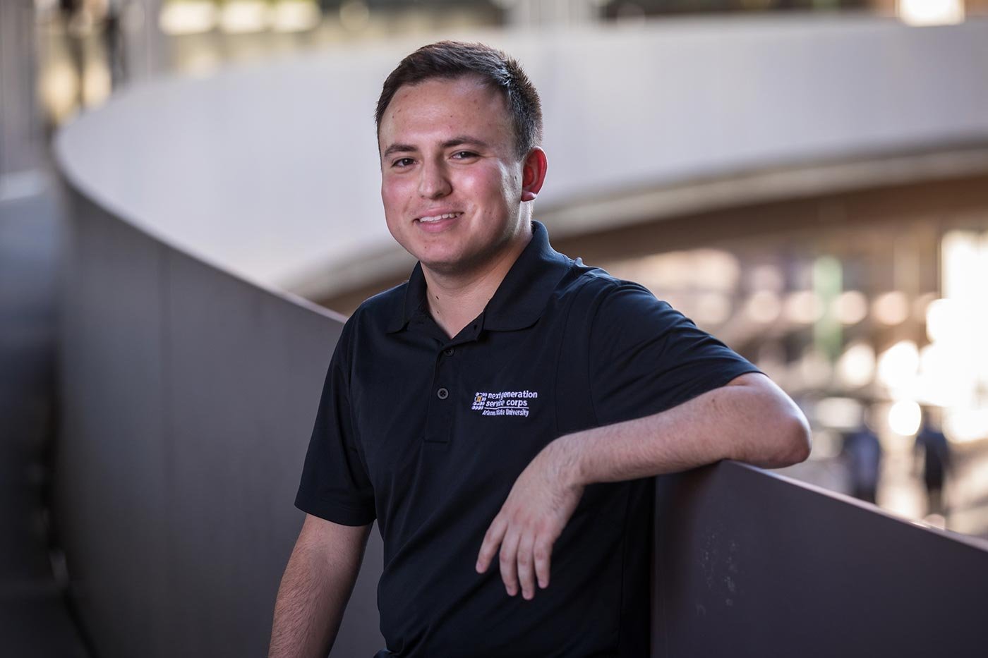 A student poses confidently against a curved wall, reflecting the leadership focus of ASU's Public Service and Public Policy program.
