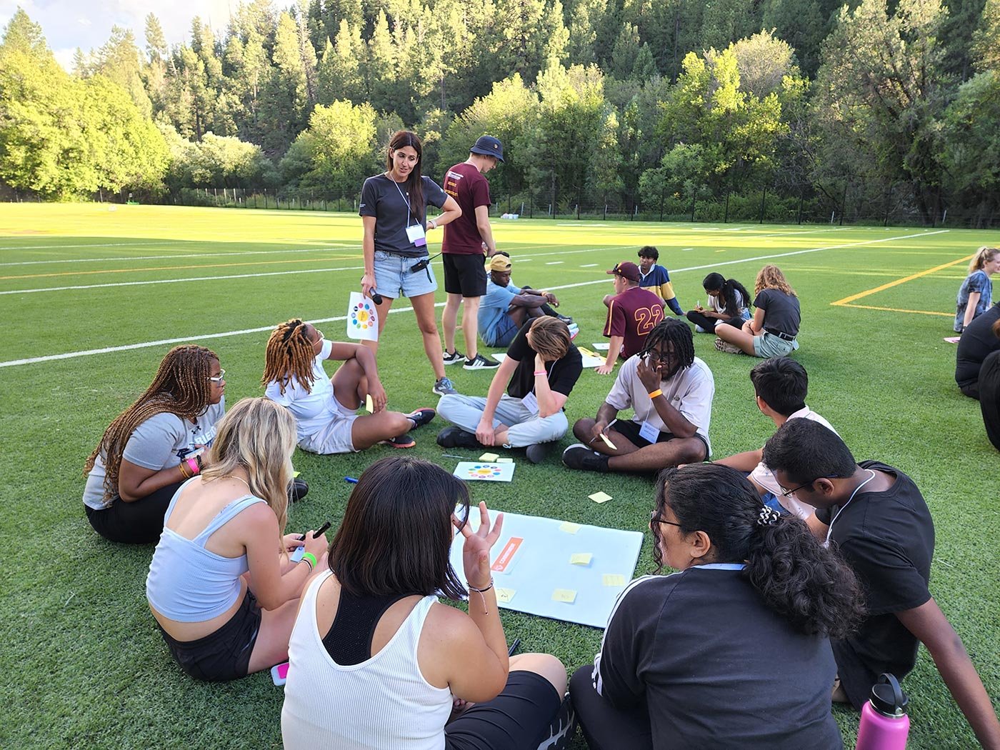 Students engaged in a collaborative activity on a grassy field, focused on team-building as part of their minor program in Recreation Management.