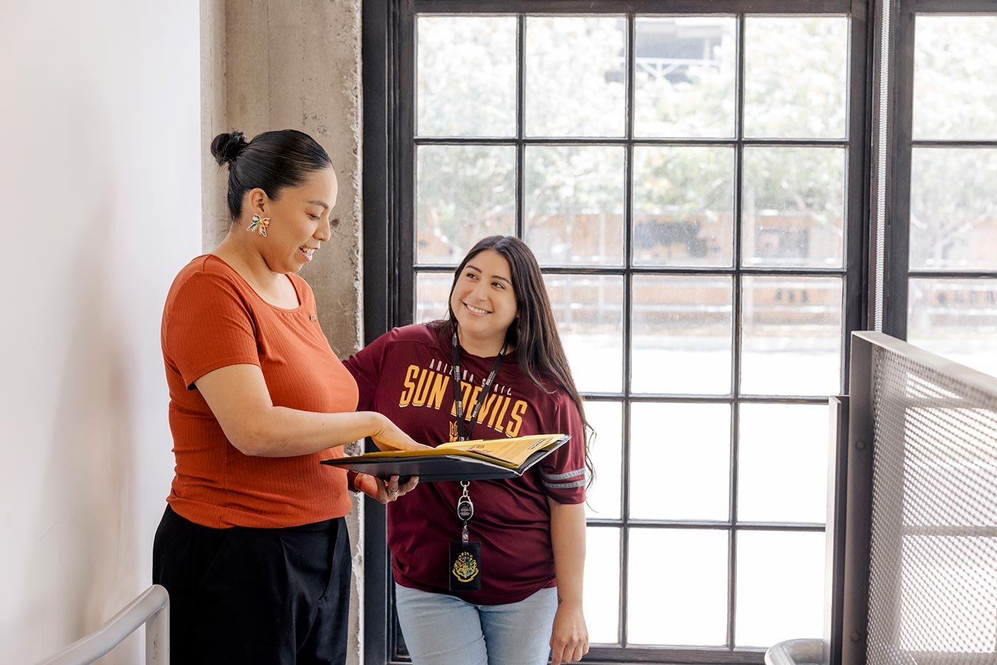 Students discuss materials in a bright, modern space with large windows, highlighting collaboration in ASU's BSW in Social Work program.