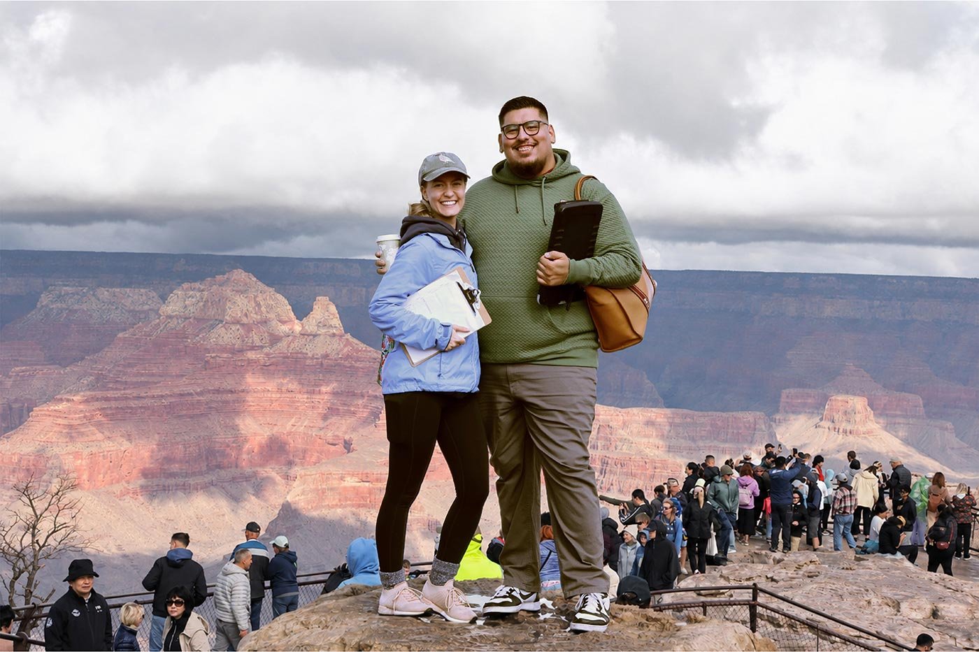 A woman and man smile for a photo at the Grand Canyon's edge, capturing the exploration central to ASU's Tourism Development degree.