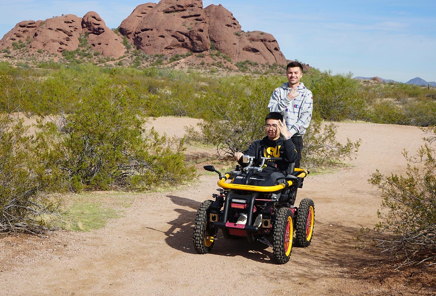 A student of the BS in Sport and Recreation Management program enjoys outdoor activities in a desert landscape while riding a mobility vehicle.