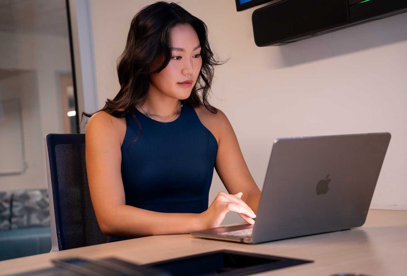 A professional works on a laptop in an office, showing digital leadership in ASU's Global Management (Global Digital Transformation), MGM program.