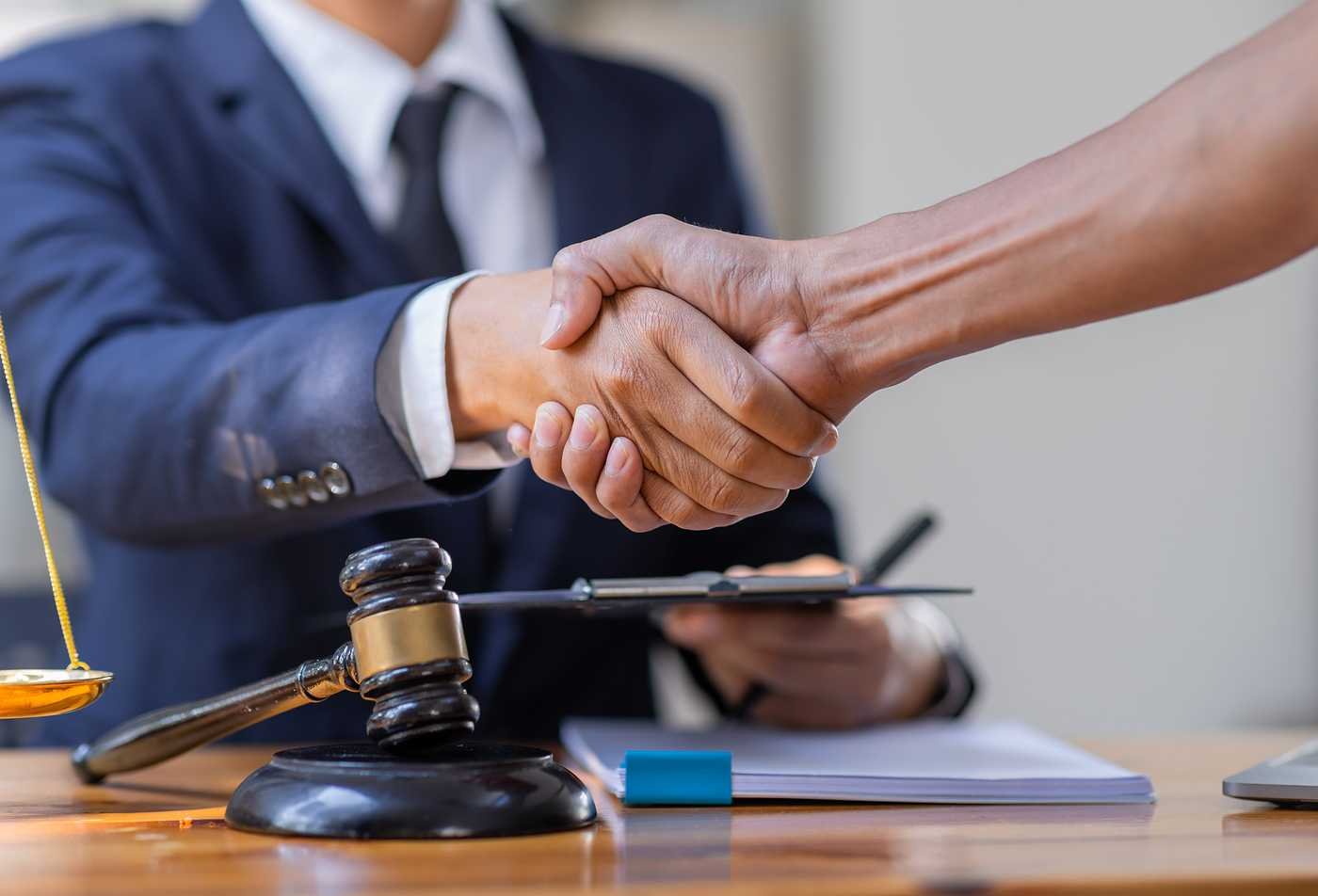 A legal agreement is finalized with a handshake, highlighting global legal expertise explored in ASU's Global Management (Global Legal Studies), MGM program.