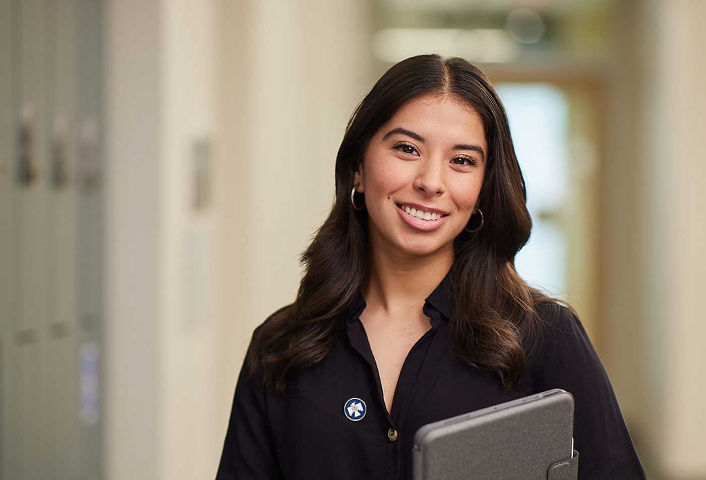 A business leader smiles in a hallway, showcasing leadership in ASU's Leadership and Management, MLM program.