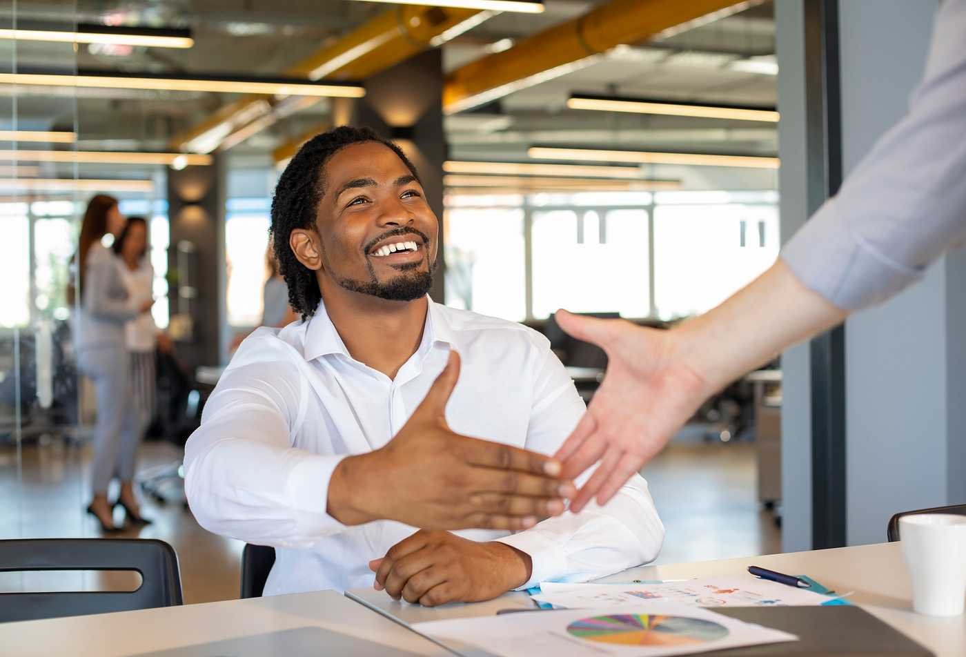 A professional greets a colleague with a handshake, highlighting relationship-building in ASU's Global Management certificate program.