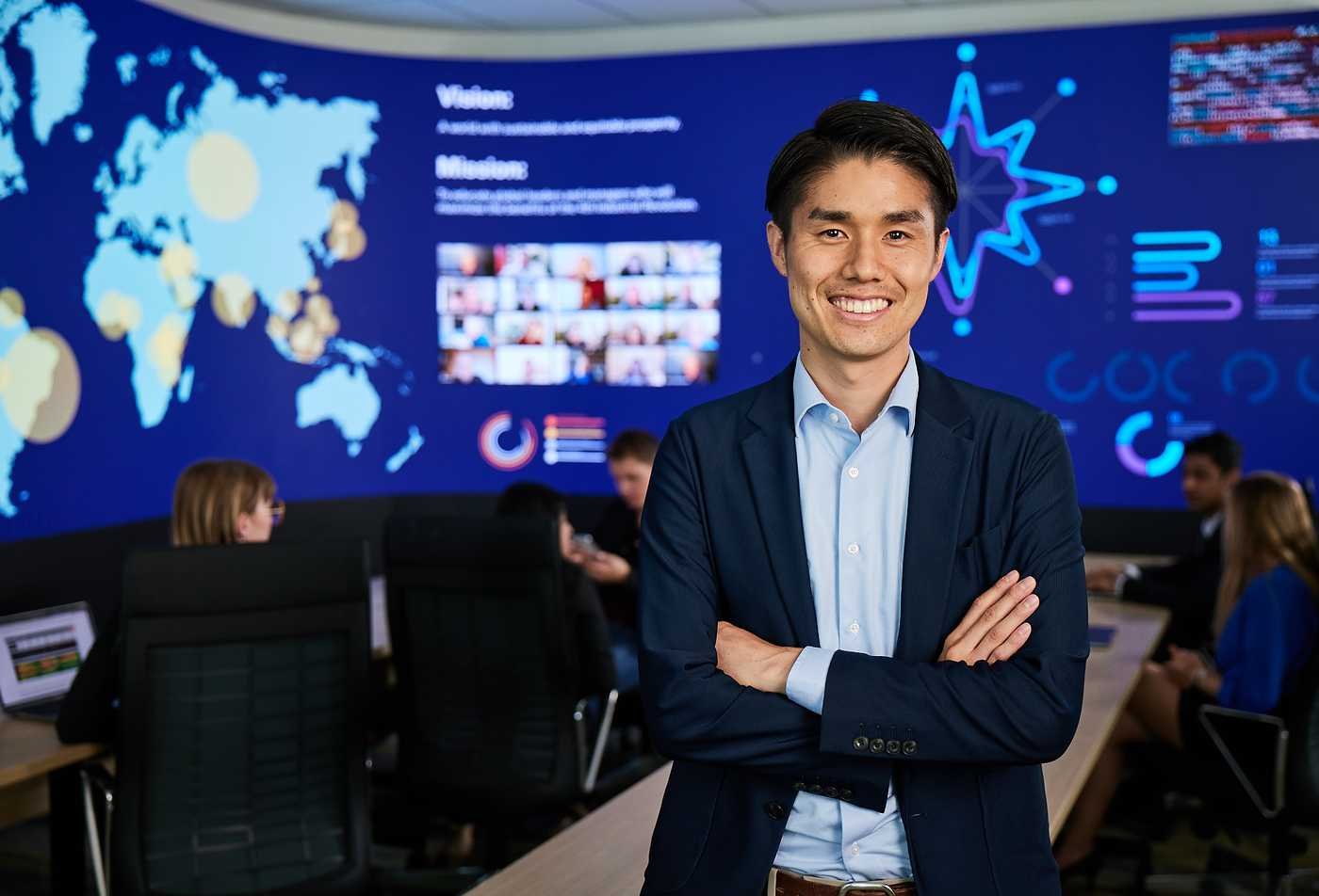 A leader stands before a global operations center, representing strategic management in ASU's Global Management, MGM program.