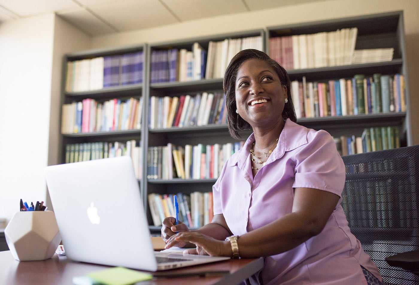 A professional studies at a laptop, showcasing professional learning in the MED in Educational Leadership.