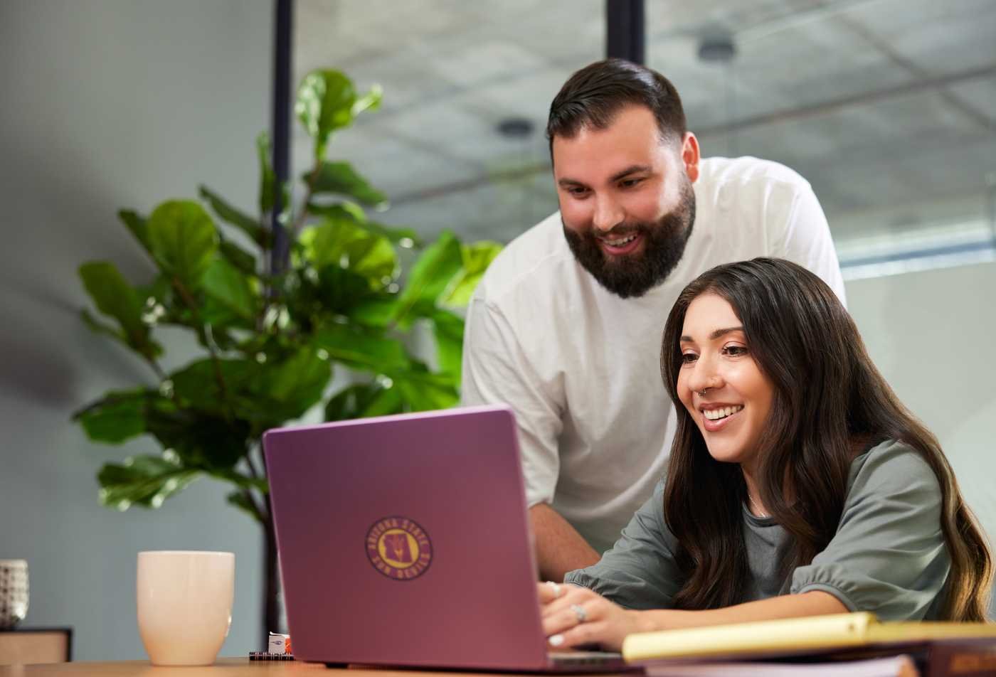 Two students collaborate on a laptop, exploring the field of Behavior Analysis through the minor program.