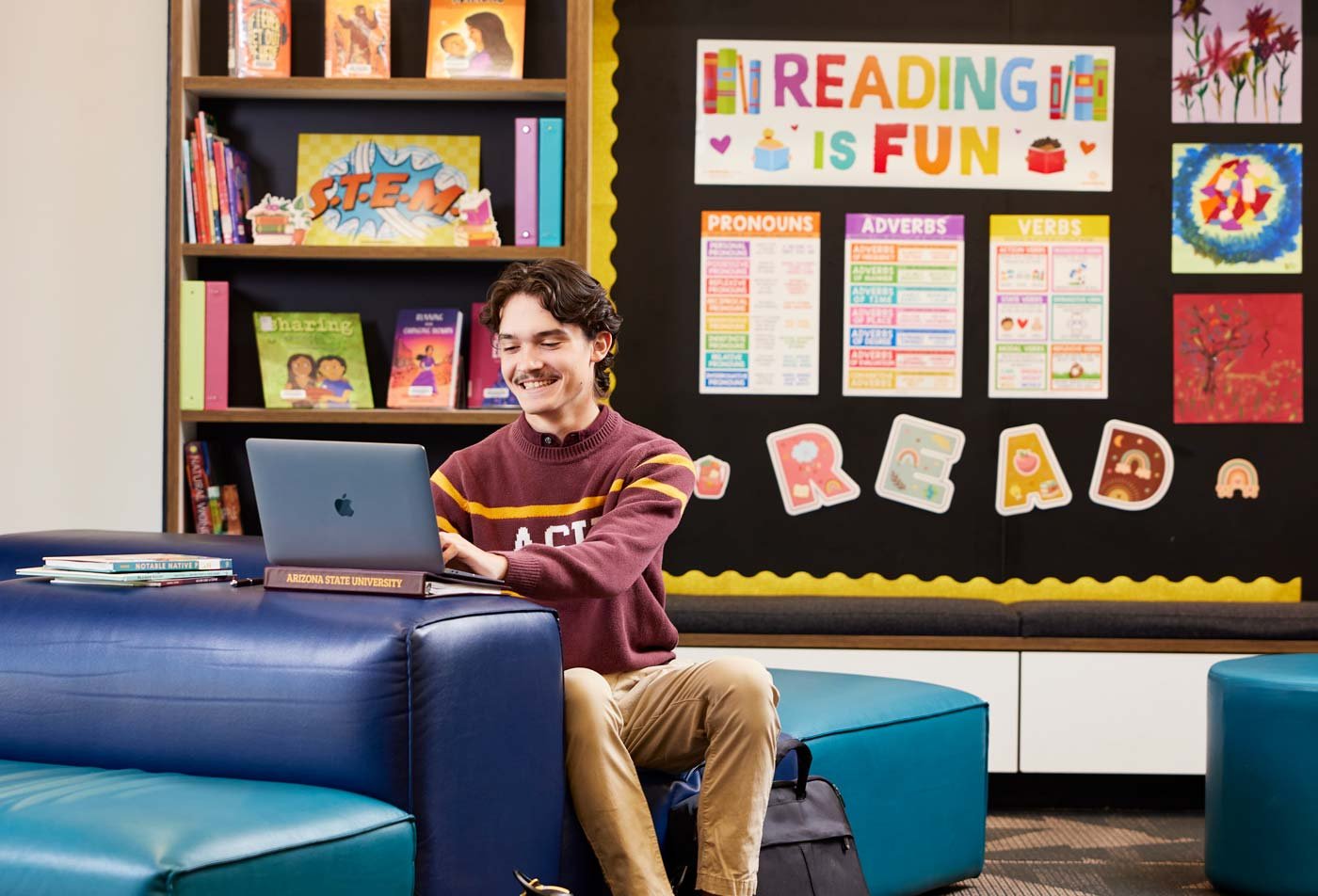An ASU student uses a laptop in a elementary classroom, preparing to use the knowledge he gained in the BEd in Education (Elementary Education).