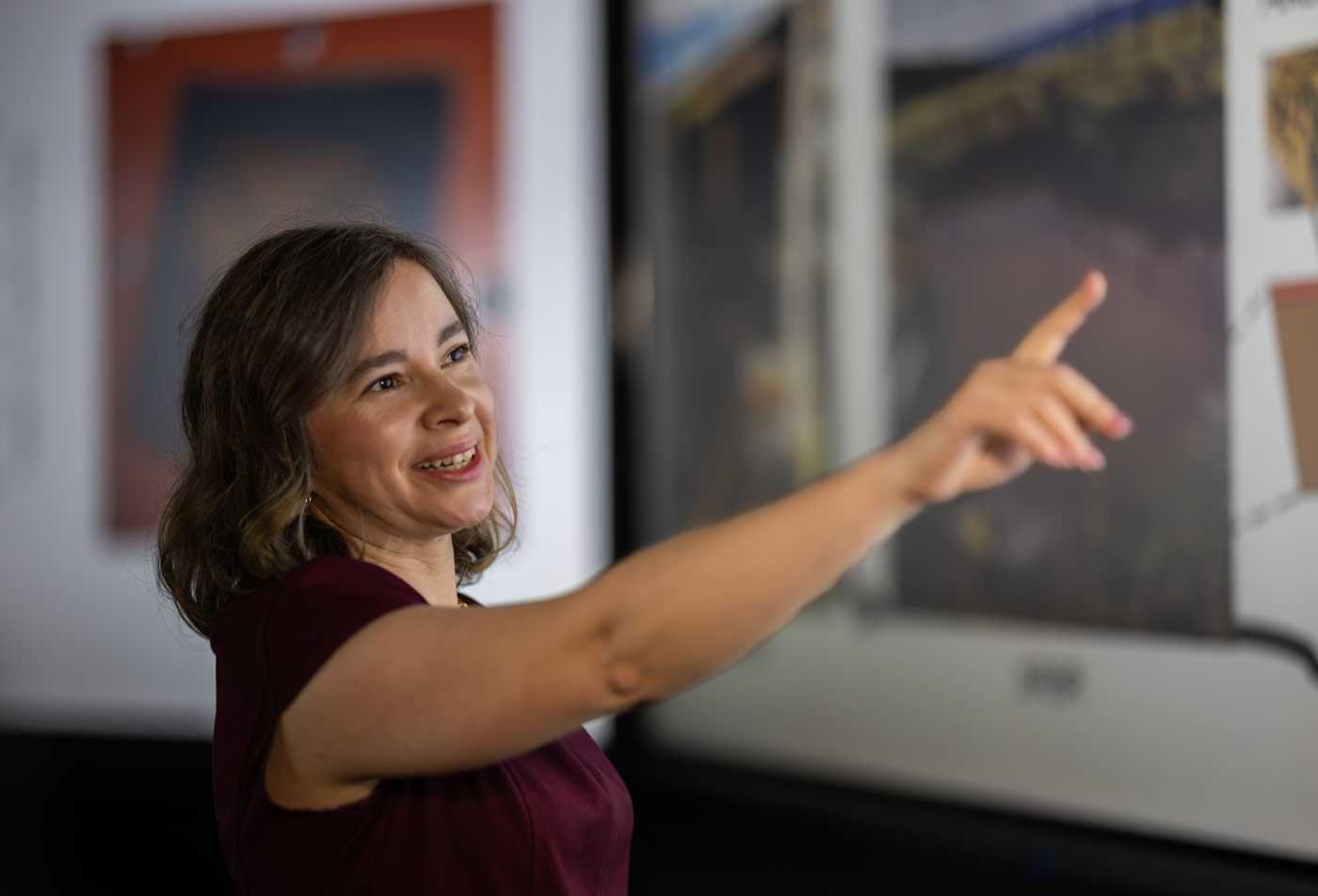 A professional gestures to some visuals, showcasing the knowledge gained in the minor in Instructional Design.