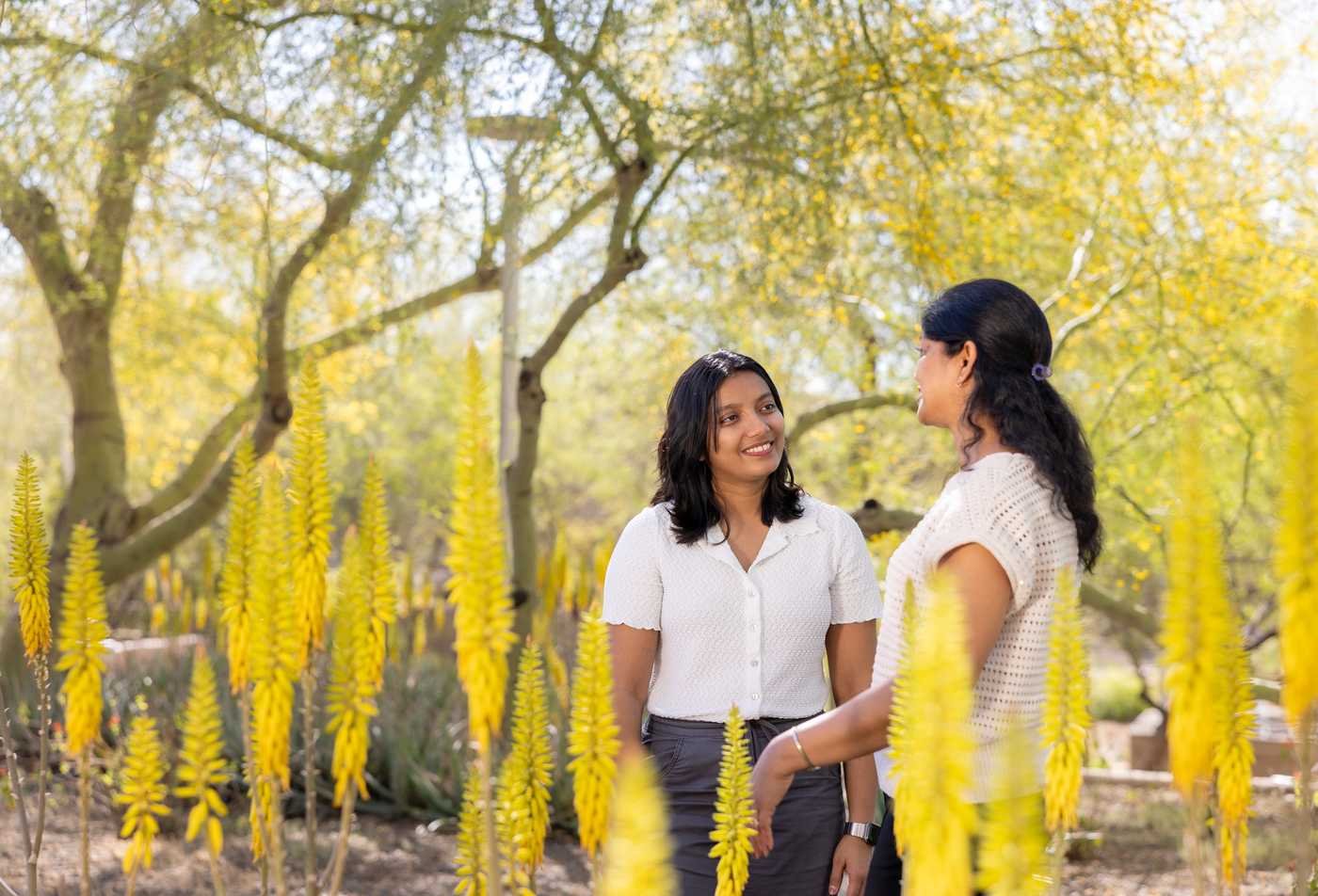Two students engage in conversation in a beautiful outdoor setting, symbolizing community in the certificate in Mild/Moderate Special Education.