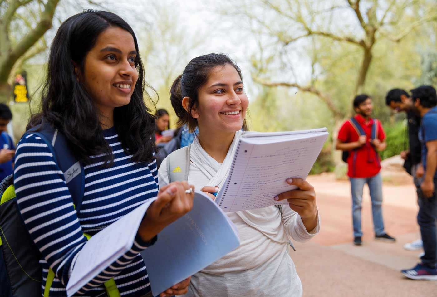 Students study the notes they took on a field trip outdoors, demonstrating the population served by the students of the MEd in Secondary Education.