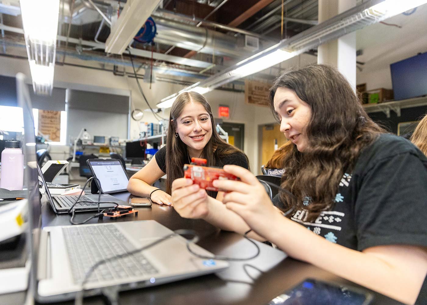 Student demonstrates computer hardware to a peer in ASU's Exploratory Math, Physical Sciences, Engineering and Technology program.