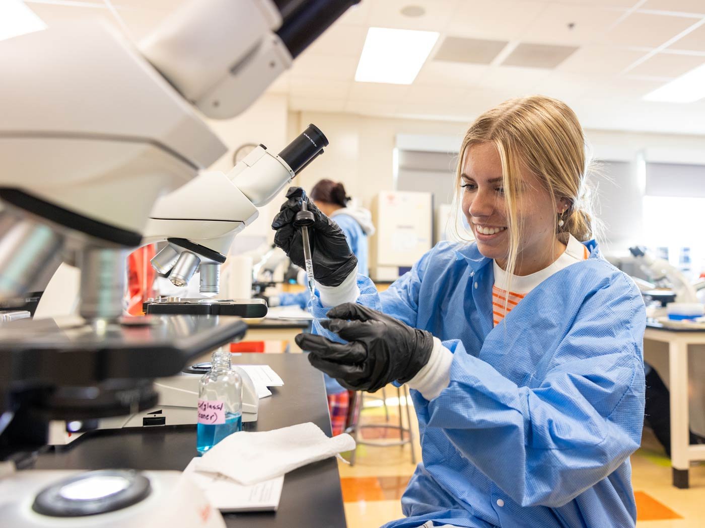 Students engage in laboratory work, handling equipment while exploring scientific principles in ASU's Work+Life Design certificate program.