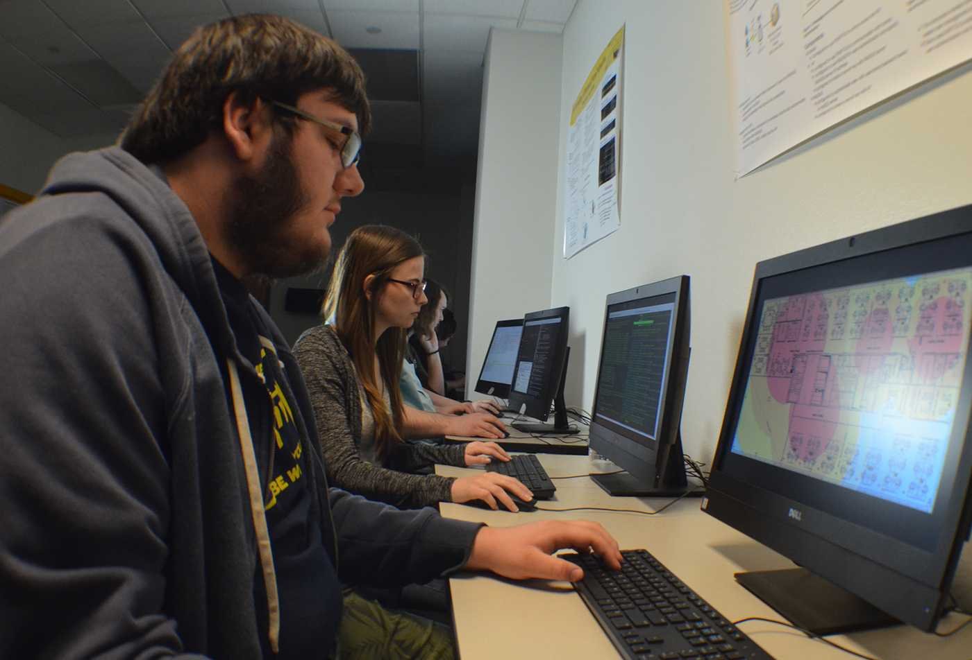 Students analyze digital systems at computer workstations, building practical skills in ASU's Applied Cybersecurity certificate.
