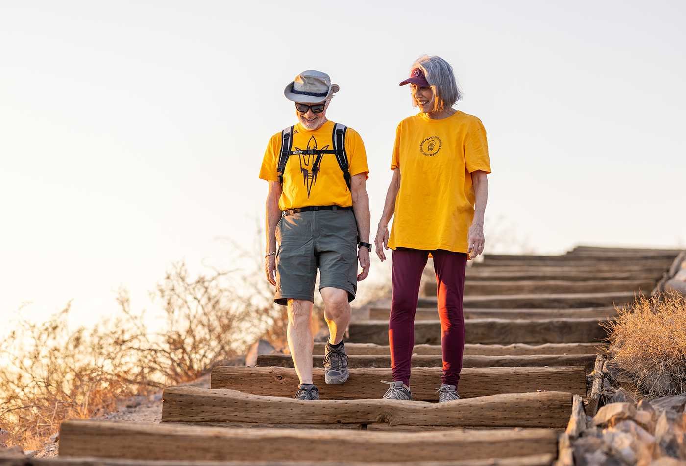 Two older adults walk together along a desert trail, reflecting population served by graduates of ASU's Aging, BS program.