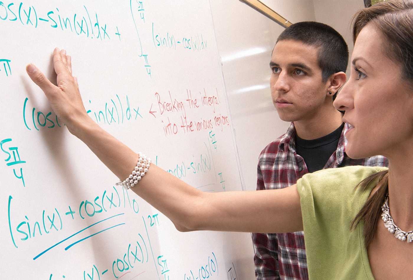 An instructor explains mathematical equations on a whiteboard, demonstrating analytical problem-solving in ASU's Applied Mathematics minor.
