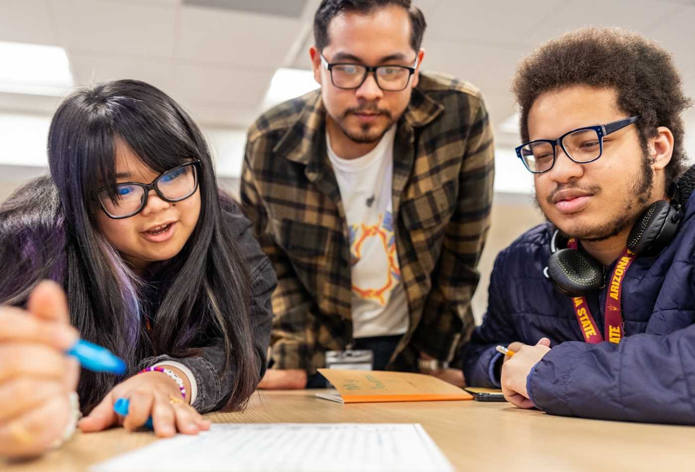 Students collaborate around written work, exploring human behavior and society in ASU's Applied Social Sciences certificate.
