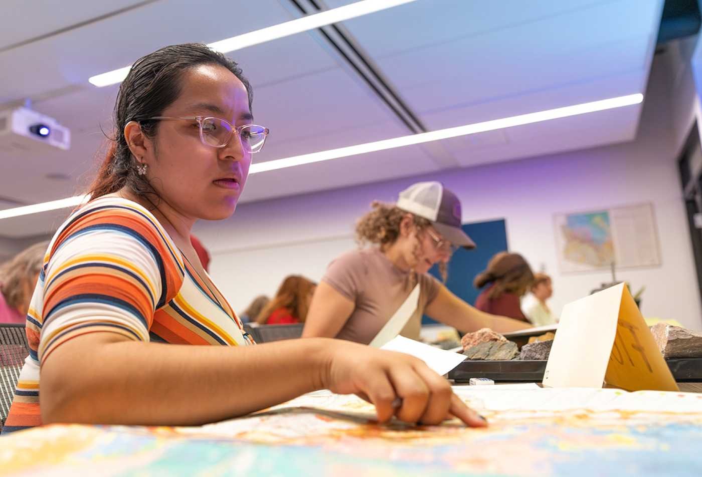 A student studies a map in a classroom, exploring human societies in ASU's Sociocultural Anthropology minor.