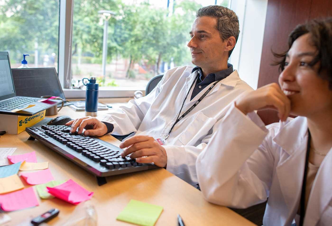 Researchers analyze biological data at computers, reflecting interdisciplinary work in ASU's Biological Data Science, MS program.