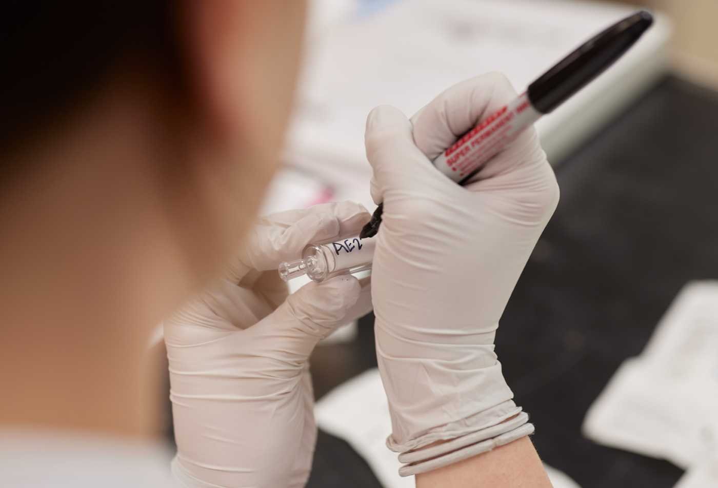 A researcher labels water samples for analysis, demonstrating fieldwork in ASU's Environmental Science (Environmental Justice), BS program.