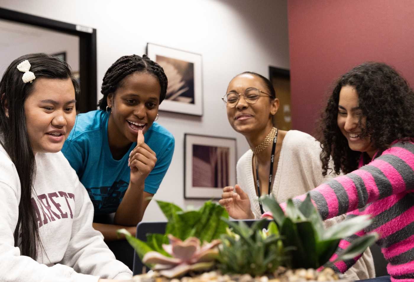 Students collaborate around a shared laptop, reflecting cross-disciplinary inquiry in ASU's Interdisciplinary Studies, MA program.
