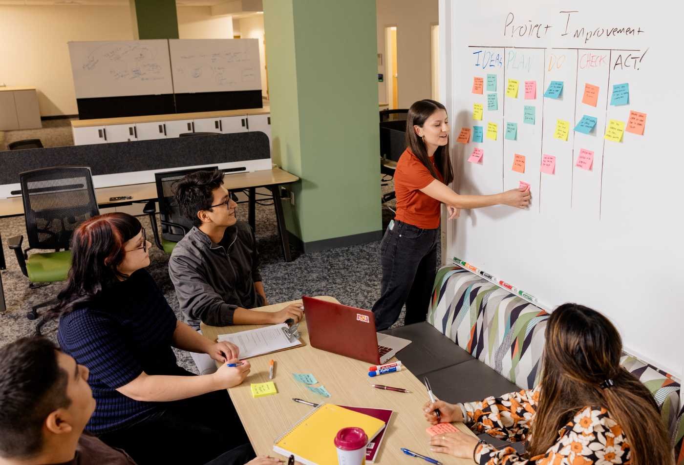 A team organizes sticky notes, reflecting workplace collaboration in ASU's Industrial and Organizational Psychology (Graduate Certificate).